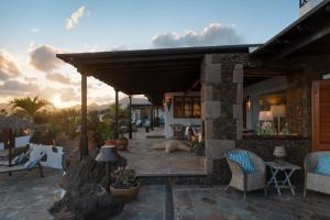 a house with a patio with chairs and a table at Lanzahost Luxury Finca Paraiso in Tías