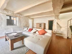 a living room with a white couch and a table at REFUGE CHAMPETRE - Moderne & Confort - Jardin Terrasse Barbecue - Parking et Wifi Gratuit - ESPACE ET DETENTE - Parfaitement équipé - Idéal FAMILLE in Saint-Coutant-le-Grand +18 photos