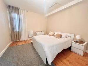 a white bedroom with a bed and a window at REFUGE CHAMPETRE - Moderne & Confort - Jardin Terrasse Barbecue - Parking et Wifi Gratuit - ESPACE ET DETENTE - Parfaitement équipé - Idéal FAMILLE in Saint-Coutant-le-Grand