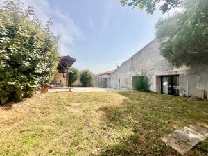 an external view of a building with a yard at REFUGE CHAMPETRE - Moderne & Confort - Jardin Terrasse Barbecue - Parking et Wifi Gratuit - ESPACE ET DETENTE - Parfaitement équipé - Idéal FAMILLE in Saint-Coutant-le-Grand