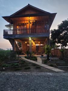 a house with a balcony on top of it at Bua Guest House in Medan
