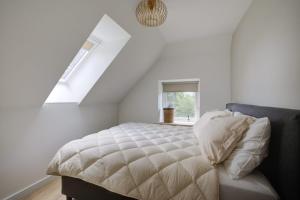 a white bedroom with a bed with a window at Drents moment in Benneveld