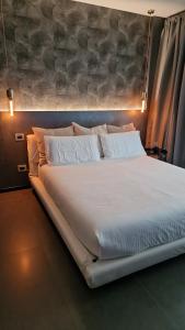 a large bed with white sheets and pillows at My home in Sarzana in Sarzana
