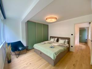 a bedroom with a bed and a blue chair at PS36 Holiday Home Siófok in Siófok +34 photos