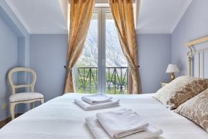 a bedroom with a bed with towels on it at Apartmani with POOL and VIEW in Gornji Orahovac +32 photos
