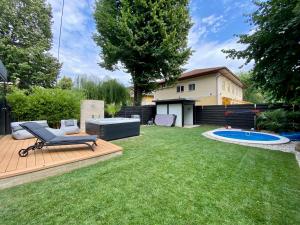 a backyard with a deck with a chair and a pool at PS36 Holiday Home Siófok in Siófok