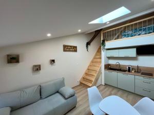 a living room with a couch and a kitchen at Le cocon mâconnais pour deux in Mâcon
