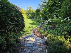 a garden with a stone path and plants at Apartament Garden- parking, ogródek, cicha okolica in Pruszcz Gdański
