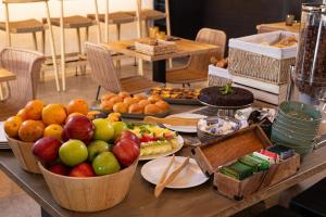a table with baskets of fruit on top of it at Hotel Baltum in Albufeira