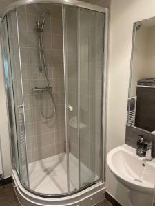 eine Dusche mit Glastür neben einem Waschbecken in der Unterkunft Queen Street Quayside Apartment, NE1 Grade 2 Listed in Newcastle upon Tyne