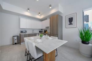 Una cocina y un comedor con una mesa y sillas blancas. en Condo with Amazing Views in the Heart of Brickell, en Miami 14 fotos más
