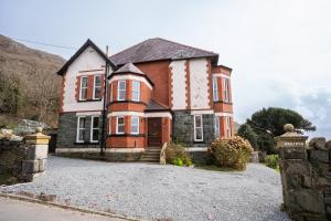 a large brick house on a gravel driveway at Haulfryn in Barmouth