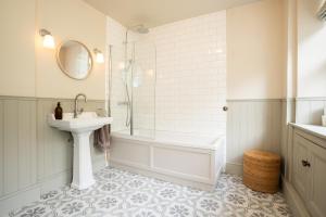 a white bathroom with a sink and a bath tub and a sink at Haulfryn in Barmouth +37 photos
