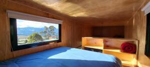 Schlafzimmer mit einem großen Fenster und einem Bett in der Unterkunft Rumi Azulada - La Calera in La Calera