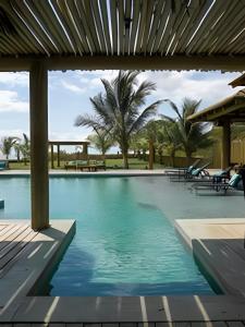 a swimming pool in a resort with palm trees at Casa Kai - Costa Dourada in Onça