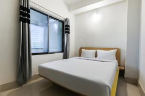 焦尔哈德Hotel Gyan Regency的有大窗户的房间里的一张床