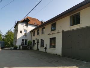 a large white building with a garage in front of it at Le Moulin d'Audenfort in Clerques