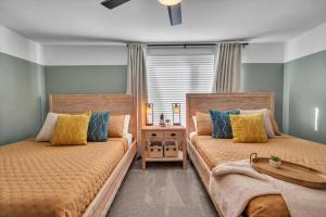 Un dormitorio con dos camas y una mesa. en Tropical Oasis, 5 Mins to Beach, en Seminole 56 fotos más