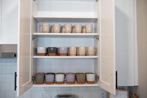 Un armario de cocina lleno de ollas y sartenes en Serene, New Apt, Pool, Long Stays, en Athens 59 fotos más