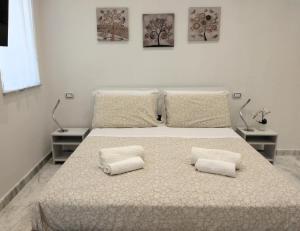 een witte slaapkamer met een bed met 2 kussens bij Lily Suite 10 in Palermo