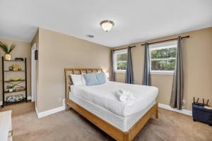 a bedroom with a large bed and two windows at Hamilton Home Playground 2BR in Lexington