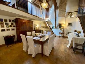 a dining room with a table and white chairs at Residenza D'Epoca San Lorenzo Tre in Todi