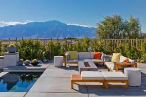 a patio with couches and a pool with mountains in the background at Ridge Overlook | Stunning Mountain Views in Desert Hot Springs