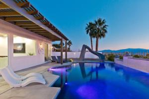 a swimming pool with a slide in a house at Ridge Overlook | Stunning Mountain Views in Desert Hot Springs