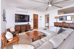 a living room with a white couch and a table at Modern Boutique Condo, Ocean Views, Great Location in El Pescadero