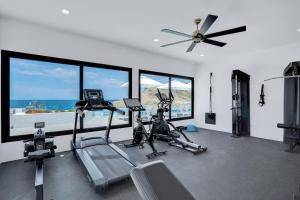 a gym with two exercise bikes and a ceiling fan at Luxury Oceanfront Condo, Resort-Style Amenities in El Pescadero