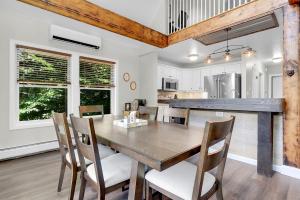 a kitchen and dining room with a wooden table and chairs at Waterfront Access with Kayaks Private Deck and a Firepit in Gray