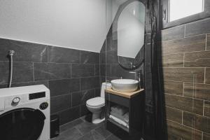 une salle de bain avec un lavabo, des toilettes et un miroir dans l'établissement Mountain Homes Durmitor 1, à Žabljak 25 autres photos