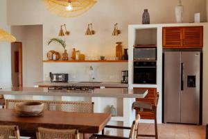 a kitchen with a refrigerator and a table with chairs at Pedasí, Playa Los Destiladeros Casa Serena in Pedasí Town