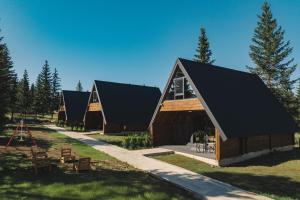 un bâtiment avec un toit noir et quelques arbres dans l'établissement Mountain Homes Durmitor 1, à Žabljak