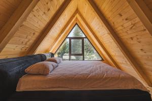 un lit dans une chambre avec une grande fenêtre dans l'établissement Mountain Homes Durmitor 1, à Žabljak