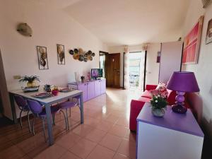 a living room with a red couch and a table at Case Vacanza a Santa Teresa Gallura in Santa Teresa Gallura
