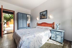 Un dormitorio con una cama con cabecero de madera. en Villa Tamaris, en Santa Eulària des Riu