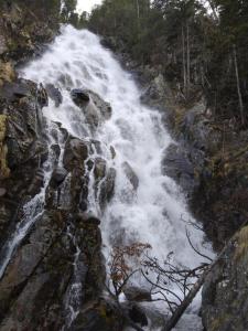 a waterfall on the side of a rocky mountain at APARTAMENTS CASA NANDO in Esterri d'Àneu