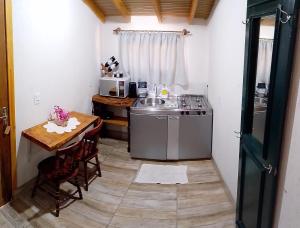 a small kitchen with a table and a stove at Sossego do Interior in Nova Petrópolis +19 photos