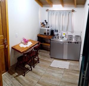 a small kitchen with a table and a stove at Sossego do Interior in Nova Petrópolis
