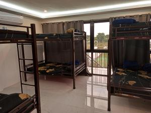 Zimmer mit 3 Etagenbetten und einem Balkon in der Unterkunft SheLiz Private Resort in Baliuag