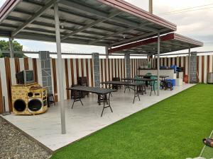 ein Metallpavillon mit Tischen und Stühlen und einer Rasenfläche in der Unterkunft SheLiz Private Resort in Baliuag