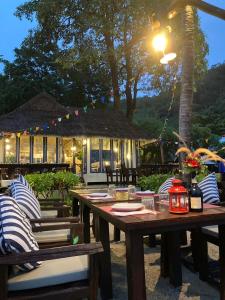 a wooden table and chairs in front of a building at Baan Thong Ching Resort in Khanom
