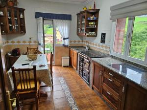a large kitchen with a counter and a sink at Ohana Campo in Illas
