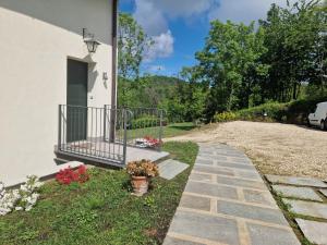 a walkway next to a house with flowers at Bellaveduta Holidays Home in Baldissero Torinese