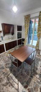 une cuisine avec une table en bois et une chaise dans l'établissement La casa di Nerone, à Acireale