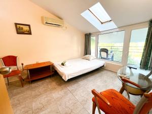 a bedroom with a bed and a desk and a window at Elite Apartments in Sunny Beach +93 photos