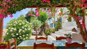 eine Terrasse mit Tisch, Stühlen und Blumen in der Unterkunft Delfinaki studio in Lionas