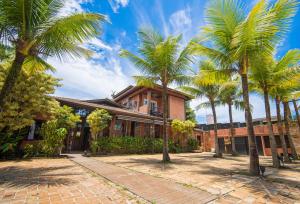 a group of palm trees in front of a building at Pousada Montão do Trigo Juquehy in Juquei