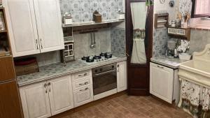 a kitchen with white cabinets and a stove top oven at Casa Guardiola 2 in Pacentro